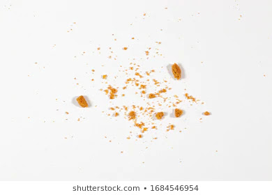 ID: small- and medium-sized crumbs of bread are scattered against a light gray background.