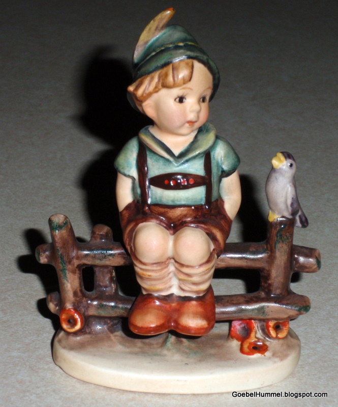 hummel boy sitting on fence