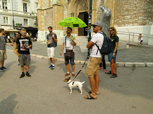 Guide Mr Eves with umbrella addressing the tourist crowd.