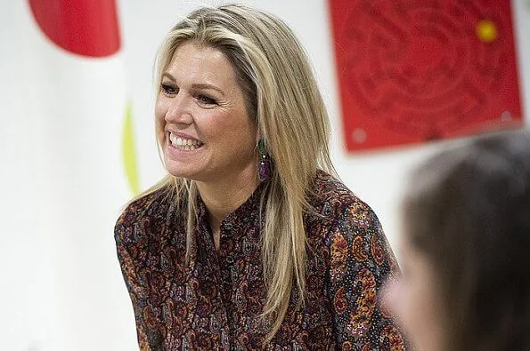 Queen Maxima wore an asymmetrical paisley print midi dress by Altuzarra, and red leather knee boots by Gianvito Rossi