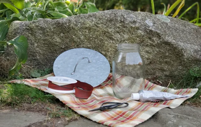 mason jar, ribbon, scissors on plaid towel