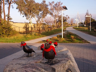 Bronze quail statues with red scarves at Mary Avenue bike/ped bridge