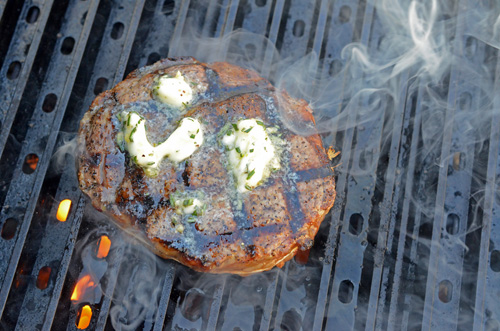 Rosemary garlic butter melting onto a thick Certified Angus Beef Brand ribeye steak from Food City.