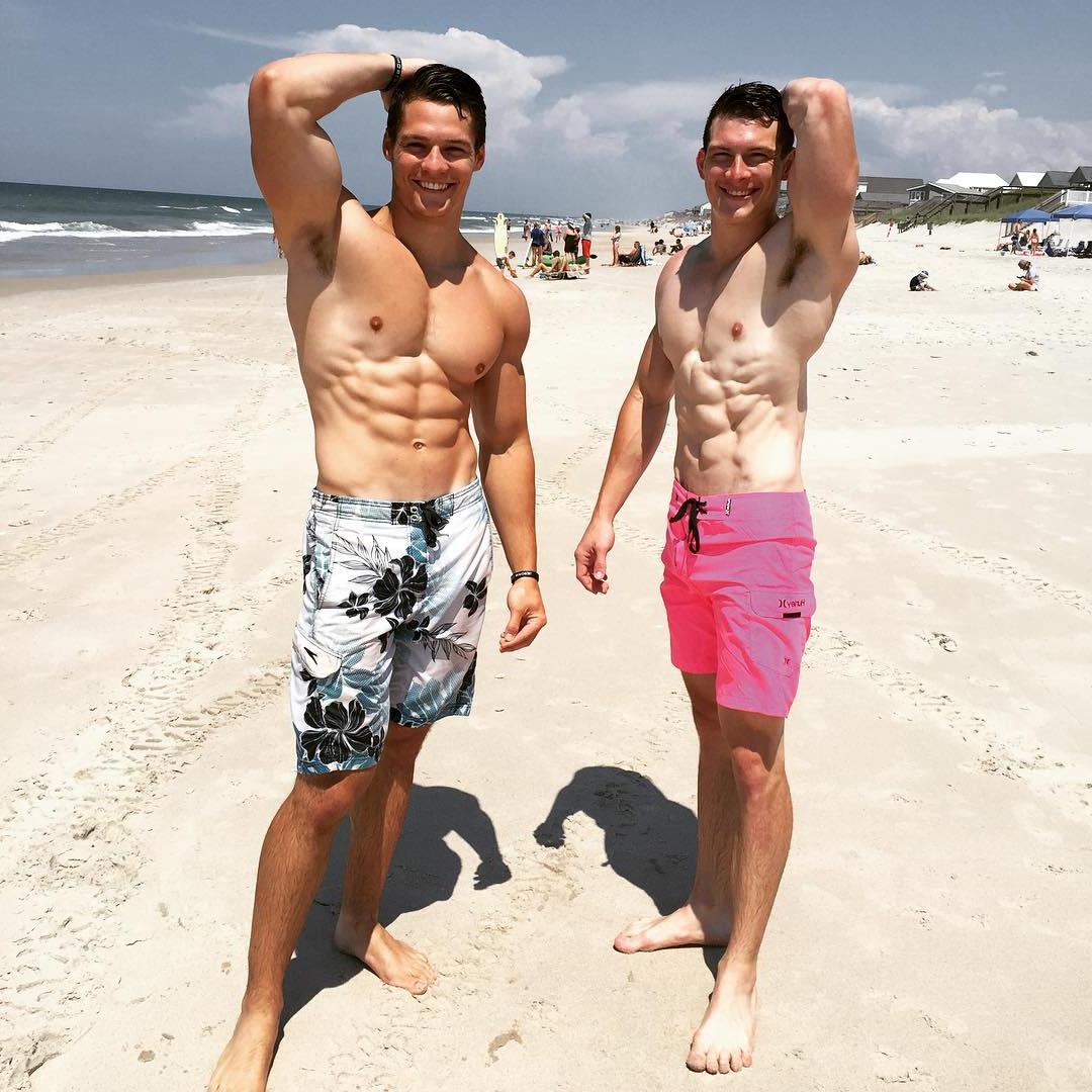 two-fit-muscular-bare-chest-straight-buddies-flexing-biceps-sixpack-abs-smiling-beach