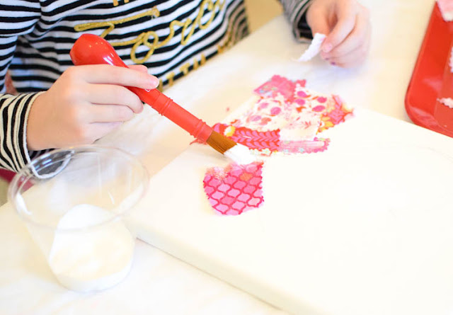 Valentine's Day Fabric Collage- use fabric scraps in shades of pink, red, and purple to make a pretty heart shape. Wonderful process art project for preschool, kindergarten, elementary, or older kids. No sewing required!