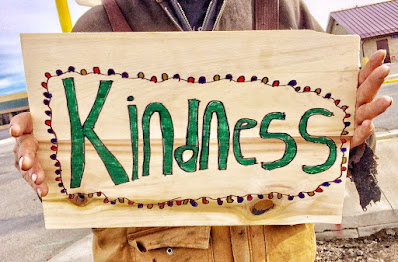 woman holding a kindness sign