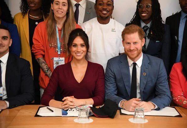 Meghan Markle wore Joseph pullover, Hugo Boss Selrita leather skirt, Sarah Flint pumps and Emily Mortimer Hera gold and diamond earrings