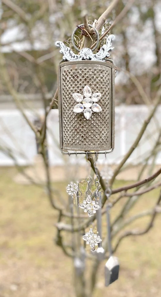Vintage grater wind chime hanging in tree
