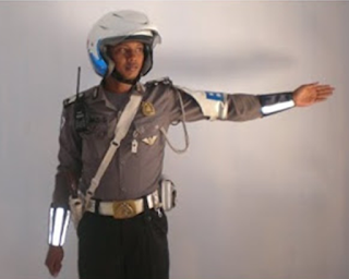 Menghentikan arus kendaraan dari arah belakang petugas