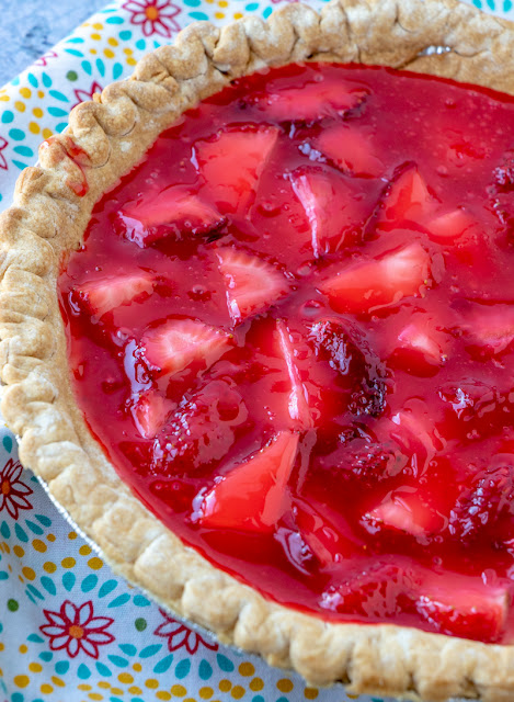 Full fresh strawberry pie, uncut on a colorful napkin