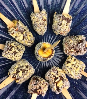 Smoked bananas covered in chocolate and coated with coconut and slivered almonds