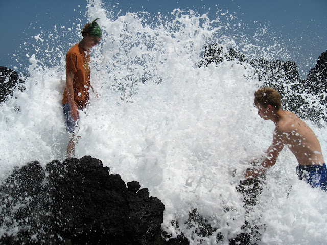 image of two boys at a rocky beach with large waves