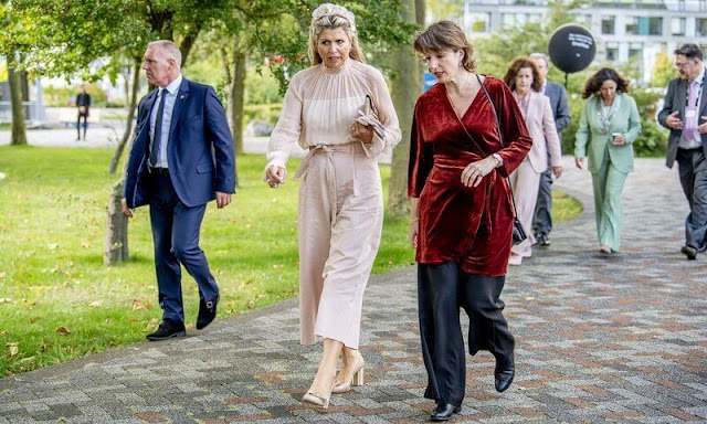 Queen Maxima wore a light baby pink tulle top and pink wide leg trousers. Salvatore Ferragamo flower heel pump shoe