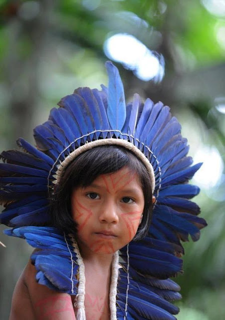 Criança indígena com cocar de penas