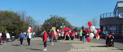 The gathering place is decorated with balloons and volunteers welcome the participants.