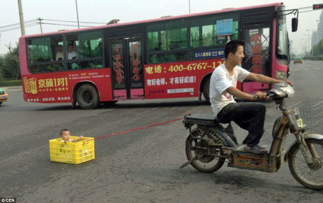 Chinês é flagrado rebocando criança numa motoneta