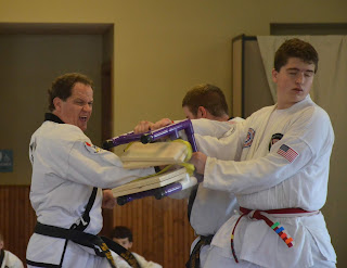 Martial arts black belt breaking board with a knifehand strike Kyle F, martial arts black belt, breaking board with a knifehand strike