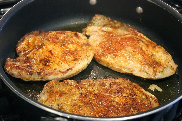 pork chops cooking in pan