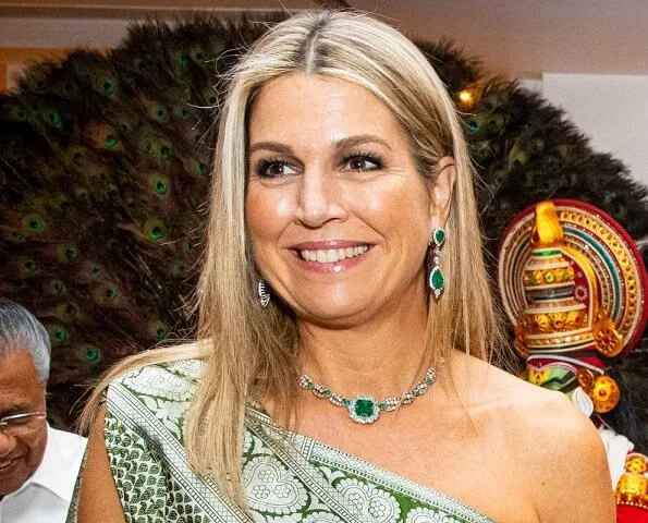 Queen Maxima wore a pale green one shoulder patterned dress which she coordinated with a bright emerald green clutch