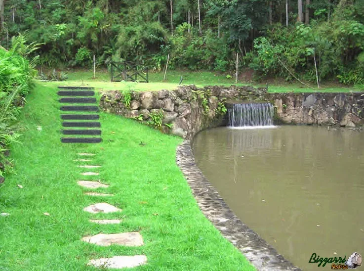 Nesse sítio em Nazaré Paulista-SP a construção dos muros de pedra rústica com a construção do lago com a escada de dormentes de madeira e o caminho com pedra São Tomé.