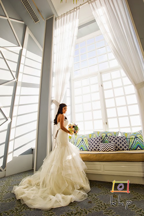 Gorgeous bride posing in front of the large windows of the Portofino Hotel's elegat lobby