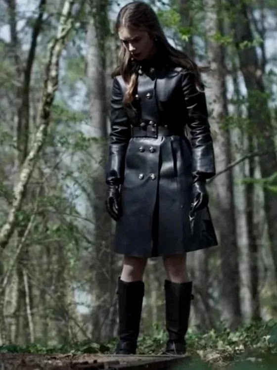 Lily Collins en Inheritance, en traje negro, en bosque.