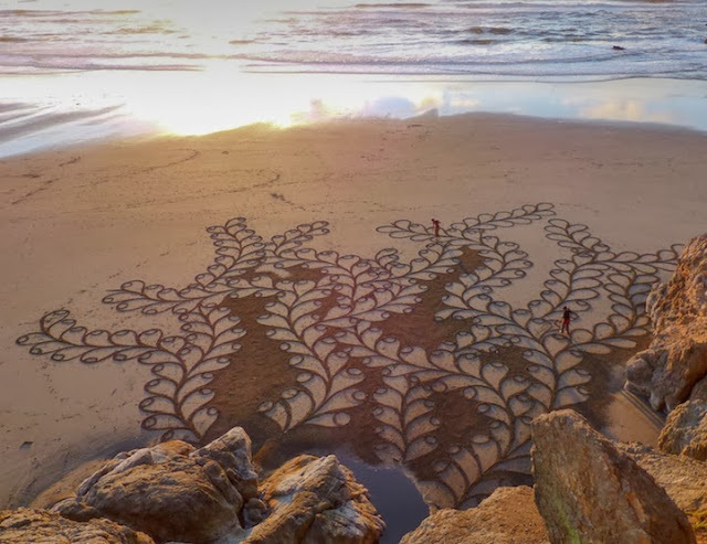 Artista utiliza un rastrillo para crear enormes pinturas de arena