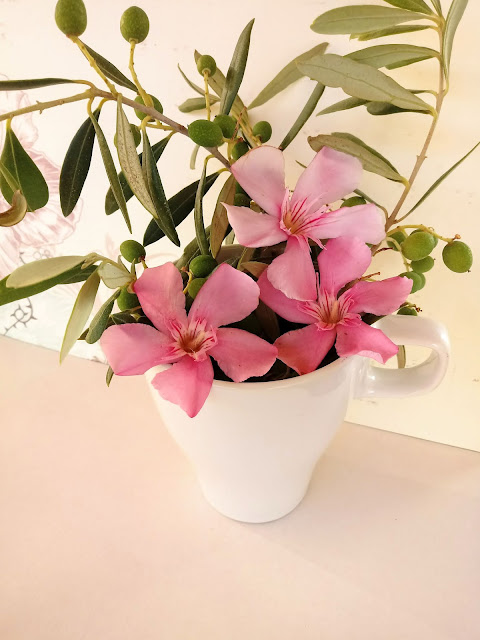 Arreglo floral con ramas de olivo y flores rosa