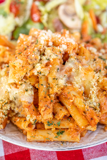 The ULTIMATE Baked Ziti - copycat Olive Garden Baked Ziti Al Forno. SUPER easy to make and tastes AMAZING! Ziti pasta, Italian sausage, spaghetti sauce, Alfredo sauce, mozzarella, provolone, ricotta, parmesan, panko bread crumbs, garlic, and olive oil. Can make in advance and refrigerate or freeze for later. Hands down the best pasta casserole we've ever eaten! #pasta #casserole #olivegarden #bakedziti #freezermeal plate of baked ziti