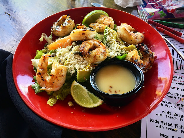 Shrimp, avocado, and grapefruit over shredded iceberg lettuce with Key Lime dressing in a ramekin on the side. 