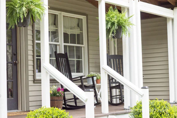 How to refinish your old wood front porch. We used Behr Cordovan Brown and Pinto White stains. The HomeRight Paint Stick helped us update our farmhouse front porch the easy way!