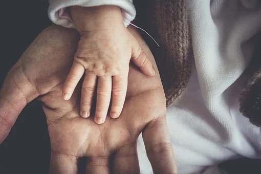 child´s hand on the palm of his father´s hand
