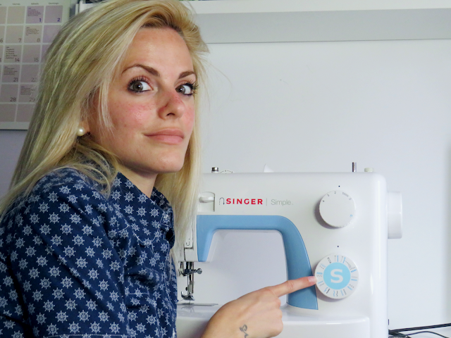 Alejandra Colomera señalando el selector de puntadas de la máquina de coser