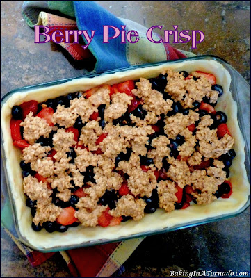 Berry Pie Crisp is a summertime favorite. An assortment of berries, mixed with a bit of toffee and baked as a pie, crisp hybrid. | Recipe developed by www.BakingInATornado.com | #recipe #pie