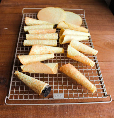 Scandinavian krumkake cookies are crunchy and delicious treats that are cooked on the stove instead of the oven. Fill them with whipped cream, fruit or frosting for an extra special dessert. krumkake cooling on wire rack