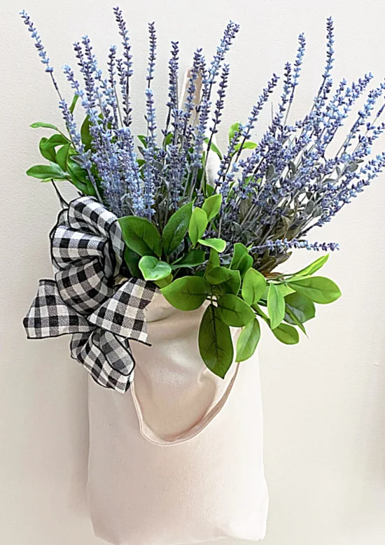 muslin tote filled with flowers hanging on wall