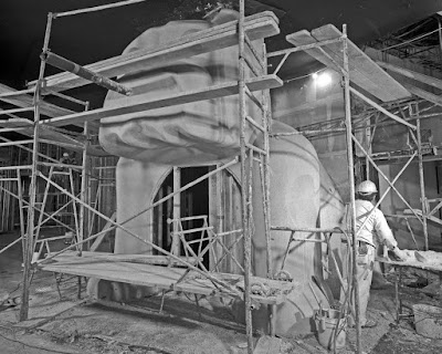 A dog-shaped building under construction inside a museum.