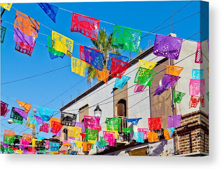 Papel Picado by Bernard Borcas Color Papel Picado strung from a white building under a bright blue sky. By Bernard Borcas.