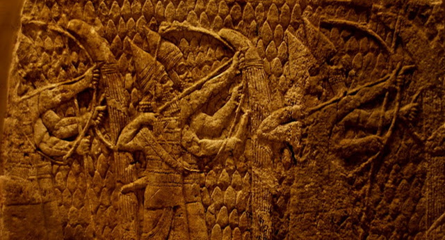 Ассирийские лучники ведут огонь по противнику во время осады Лачиша. Каждый лучник был защищен от вражеского огня носителем щита. Заостренный рисунок на заднем плане означает, что эта сцена происходит в горах. Они представляют армию царя Сеннахирима Ассирийского (царствовавшего в 705-681 гг. До н.э.), марширующего на Лахиш, древний город в 40 км от Иерусалима. Это изображение является частью серии рельефов, изображающих осаду и захват города, со стен дворца Сеннахирима в Ниневии.  (700-692г.г.  до н.э.) Британский музей, Лондон, Великобритания