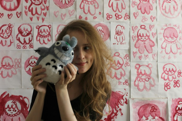 Girl holding a Totoro plush toy.