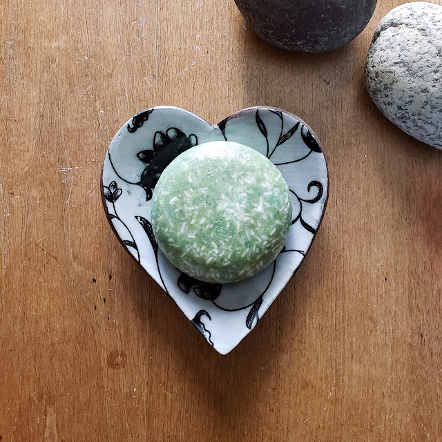 Shampoo bar sitting in a heart-shaped bowl