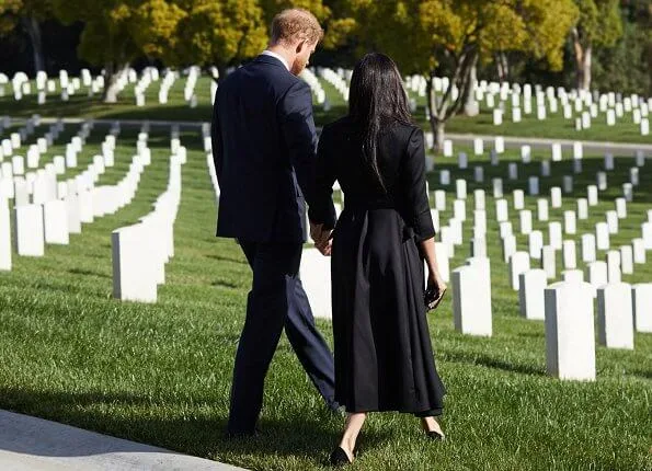 Meghan Markle wore a new black wool and silk jacket from Brandon Maxwell, and a silk belt from same brand. Jennifer Chamandi Lorenzo suede pumps