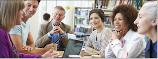 Six educators at table with laptop