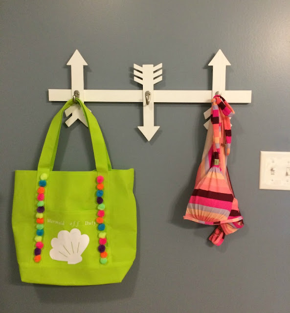I created this Wooden Arrow Wall Hooks project out of scrap wood to hold swimsuits and beach bags.
