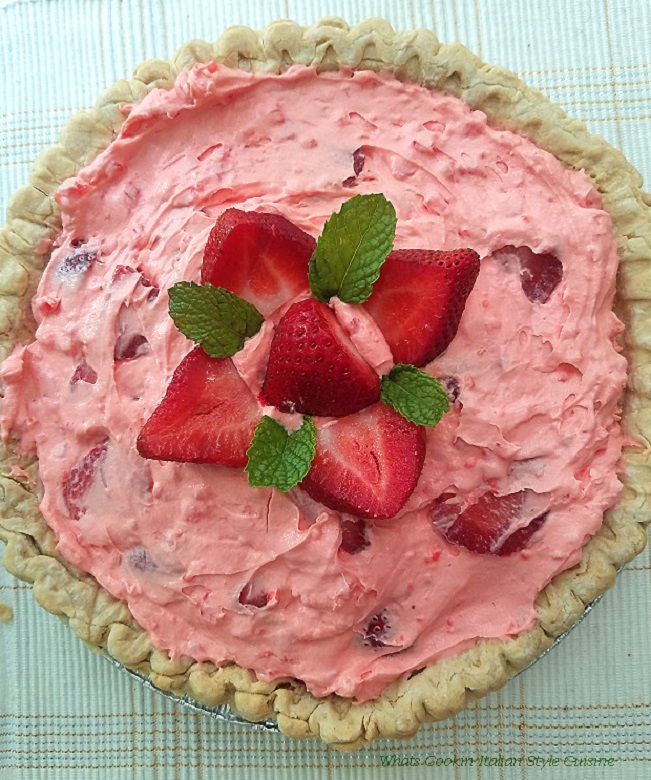 this is a strawberry cream  pie filled with strawberries, whipped cream and a jello pudding filling. Topped with a flower arrangement pattern using strawberries and mint leaves on top