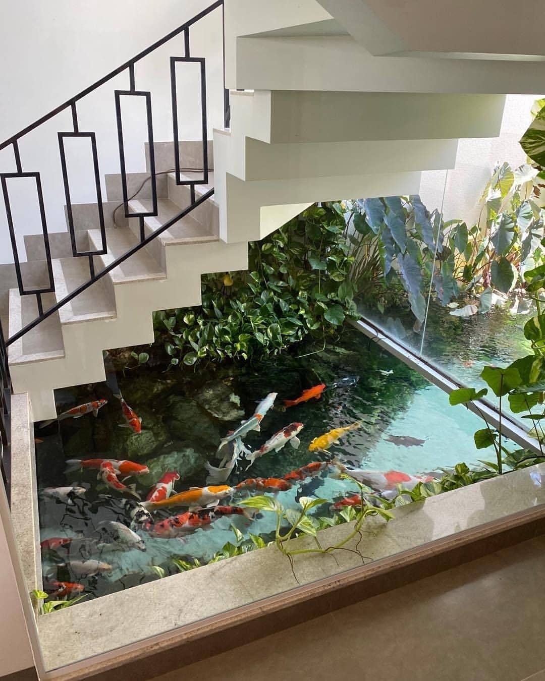 Аквариум в водоеме. Аквариум под лестницей в доме. Водопад с рыбками в аквариуме. Аквариум в интерьере зимнего сада. Аквариум с водопадом.