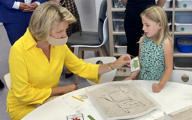 Queen Mathilde wore yellow silk shirt top and pants by Natan at primary school KAZ in Zottegem