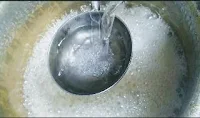 Pouring medium hot water into sugar syrup for rasgulla recipe