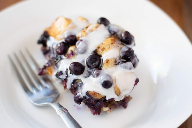 A scoop of the Crockpot Blueberry Cinnamon Bake Recipe on a white plate with a fork to the side.  