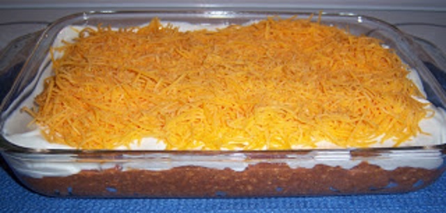 the is a Mexican refried bean dip in a large 13 x 9 glass casserole dish.